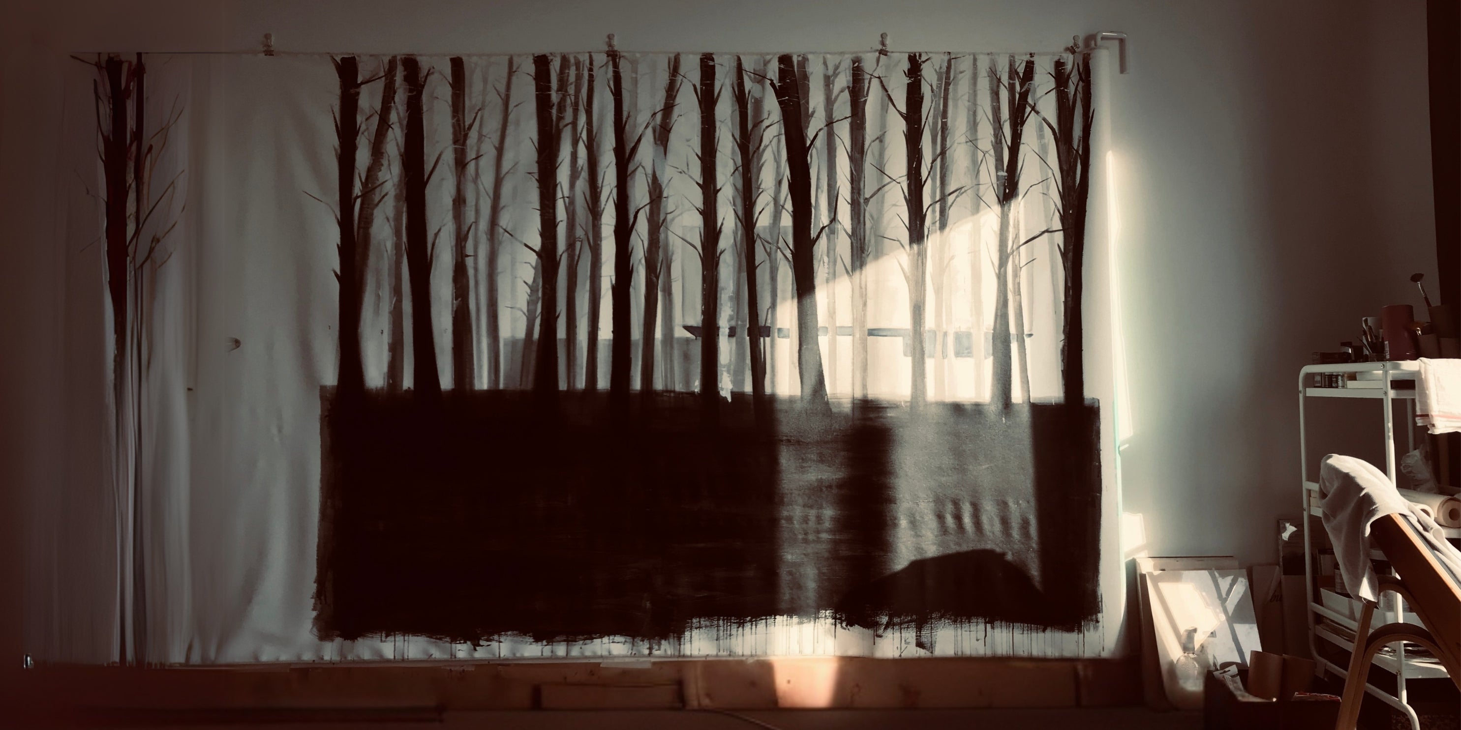 Living room with a large painting patterned with tree silhouettes by Rita Rawashdeh