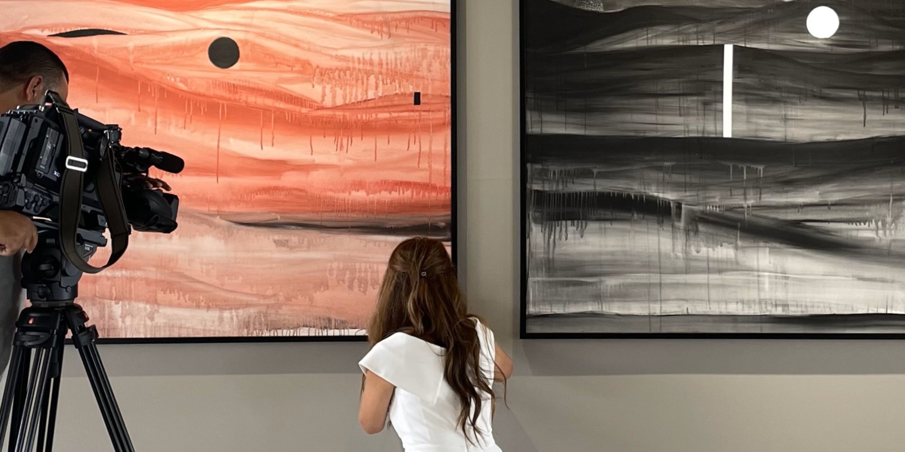 Rita Rawashdeh touching up abstract art on a wall. 