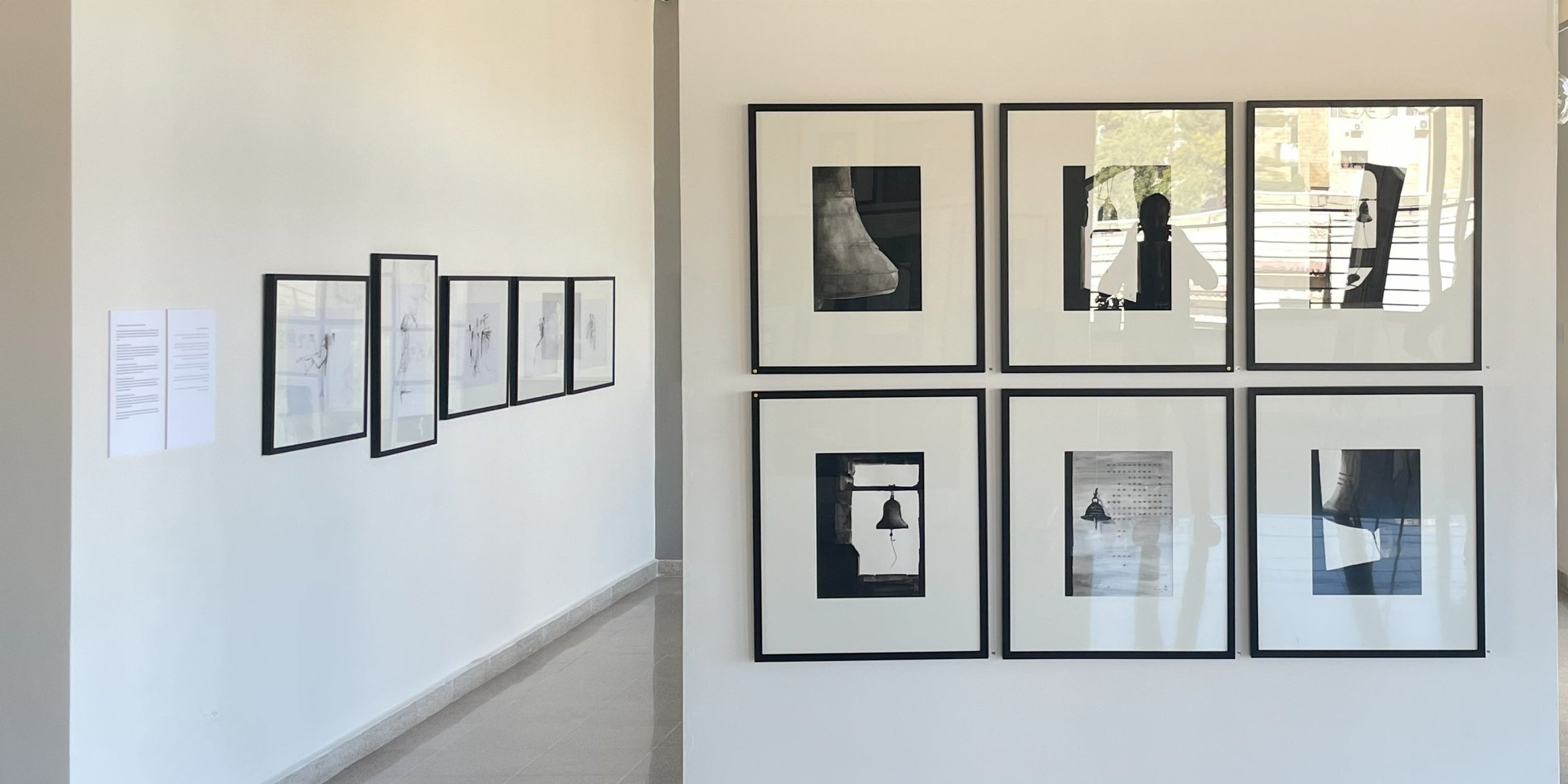 Art gallery with framed black and white photographs on a white wall by Rita Rawashdeh